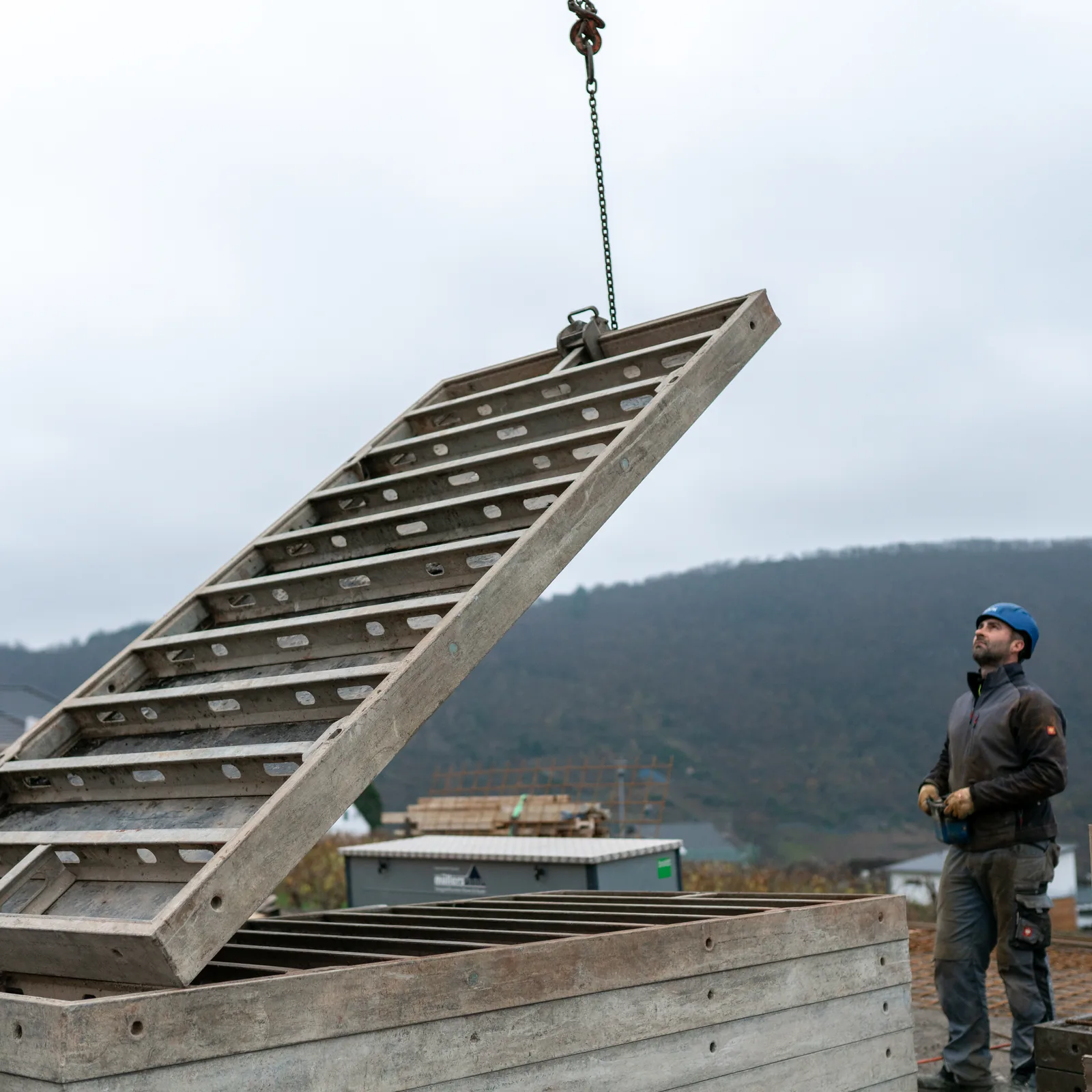 Müllers Bau – Team beim Versetzen eines Bauteils auf der Baustelle